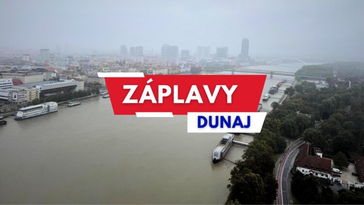 Letecký pohľad na zaplavené nábrežie Dunaja v Bratislave so zvýšenou hladinou rieky a textom „Záplavy Dunaj“ v popredí.