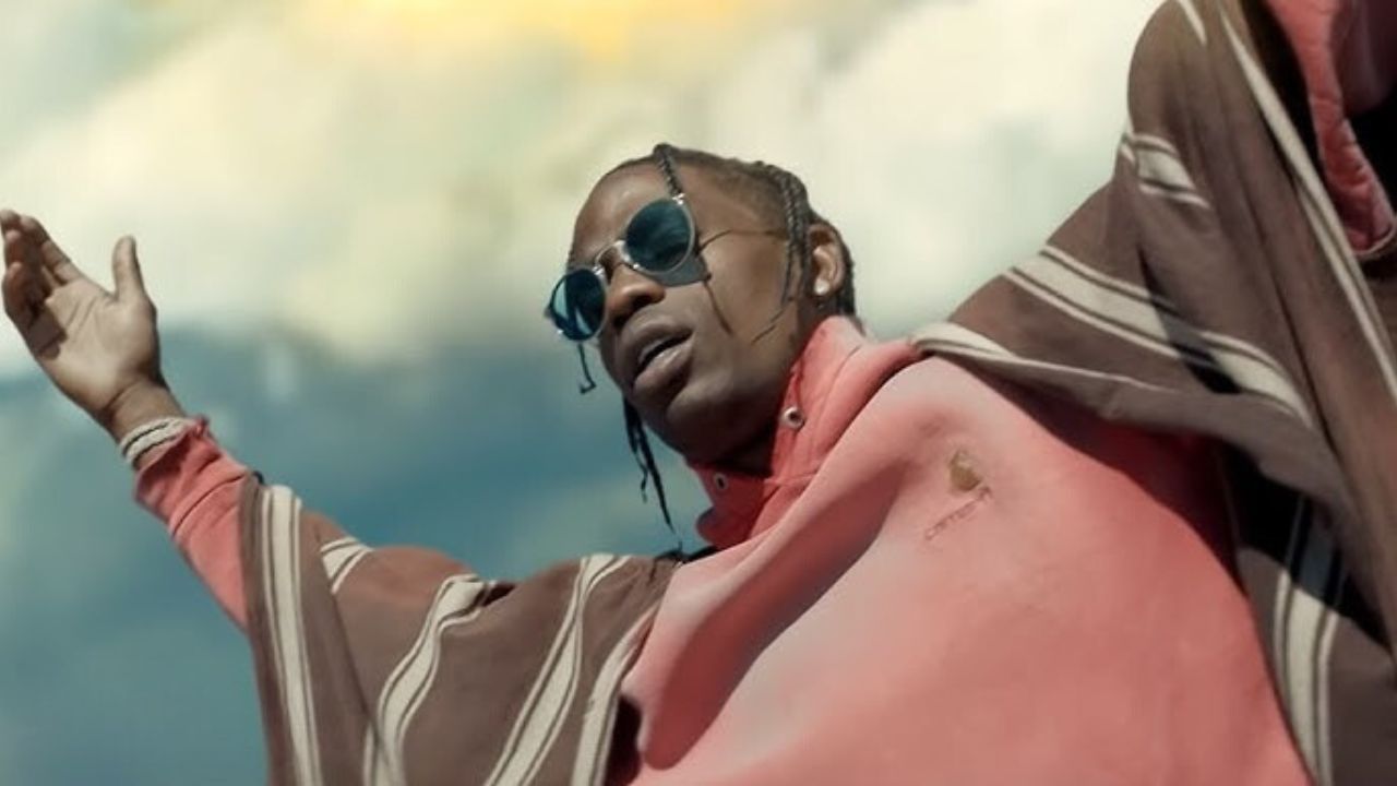 Travis Scott počas vystúpenia s rozpaženými rukami a slnečnými okuliarmi