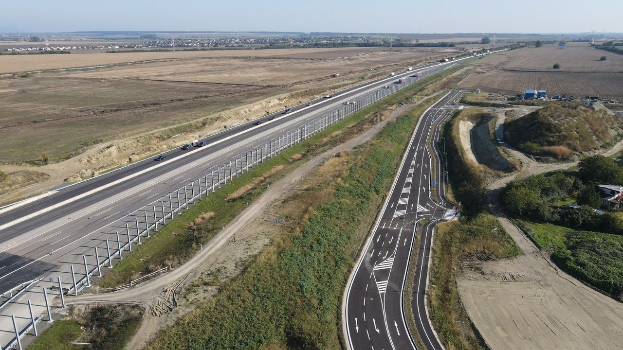 Letecký pohľad na diaľnicu D1 a okolité obchádzkové trasy, zachytávajúci modernizovaný úsek s rozdelenými jazdnými pruhmi a vidieckou krajinou v pozadí.