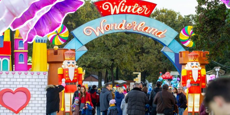 Vstupná brána do zábavného parku WINTER WONDERLAND, obklopená rozprávkovými dekoráciami a postavami luskáčika, s množstvom návštevníkov užívajúcich si zábavu.